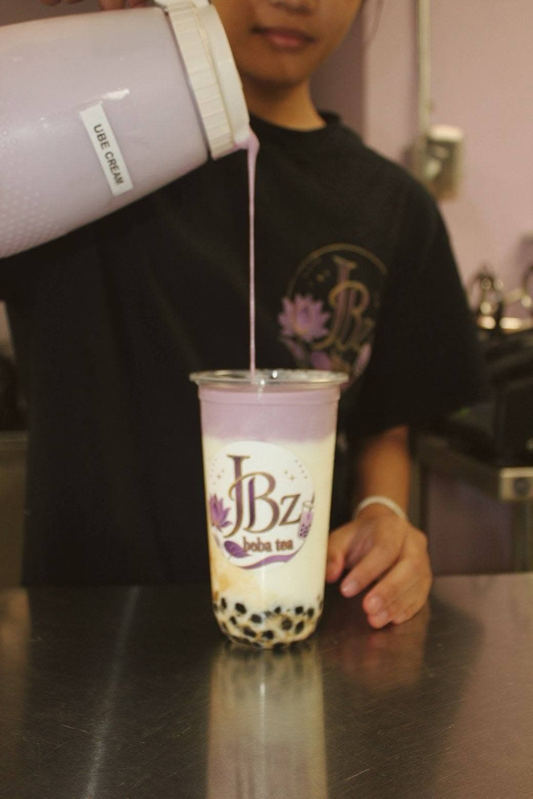 Ube cream being poured over a fresh JBz taro milk tea