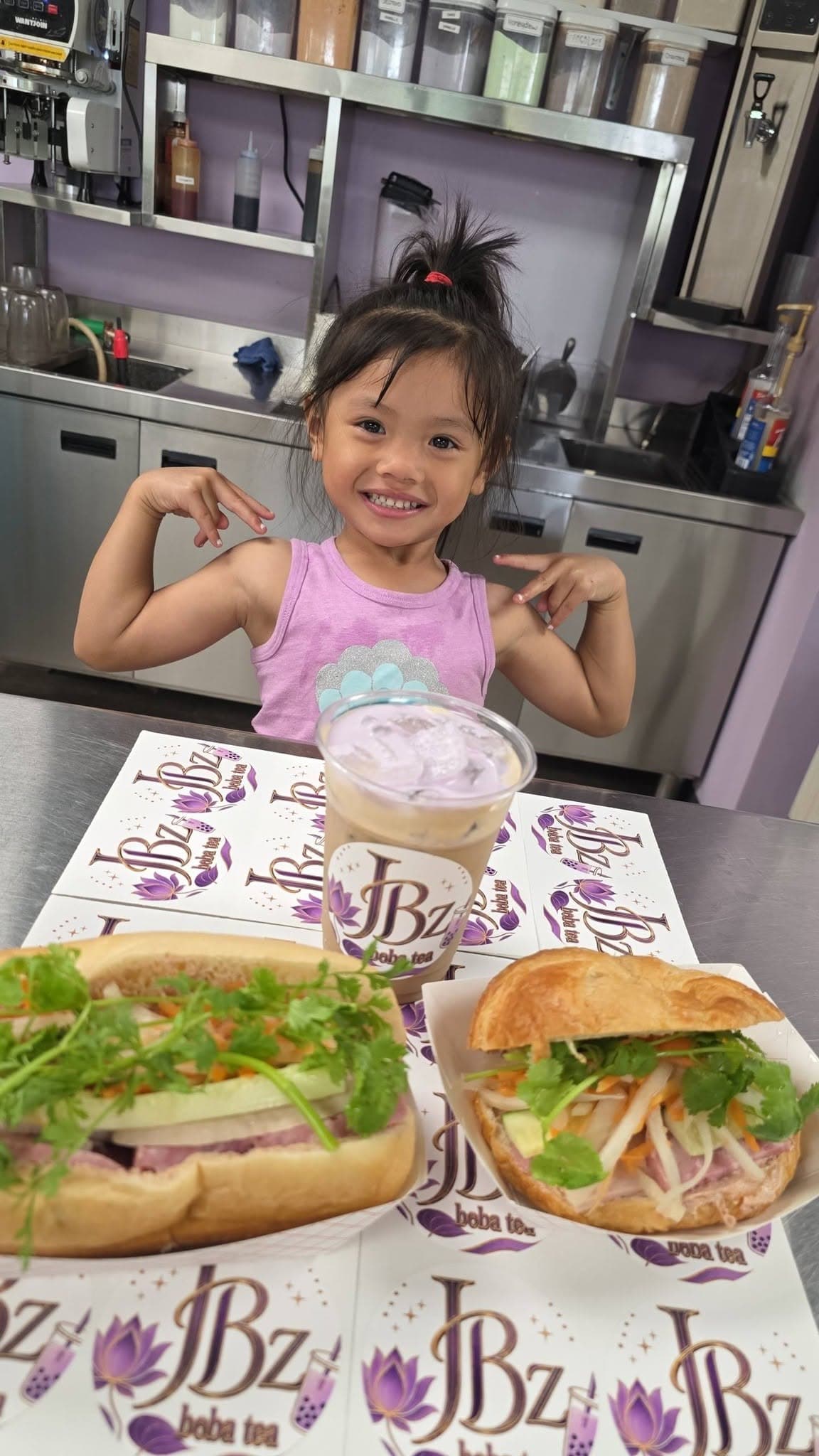 A pair of fresh JBz banh mi with an iced drink on the counter