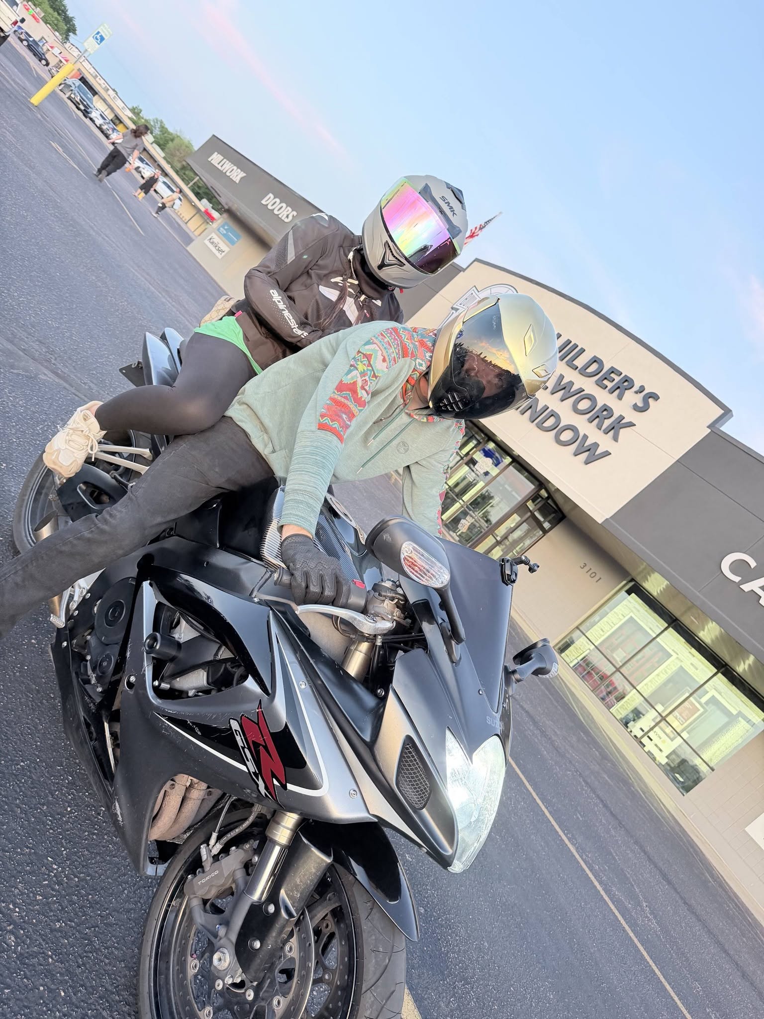 Riders on a sportbike among the cars at WHIPS